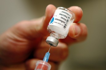 A nurse prepares an injection of the influenza vaccine at Massachusetts General Hospital in Boston, Massachusetts in this January 10, 2013 file photo. More than three-quarters of Americans who got this season's flu shot could get the virus anyway, given a mismatch between the flu strains covered by the shot and those actually causing illness in people, U.S. officials say.  REUTERS/Brian Snyder/Files    (UNITED STATES - Tags: HEALTH SOCIETY)
