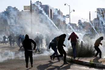 Manifestantes palestinos são alvo de bombas de gás lançadas pelas tropas de Israel perto de Ramallah, um dia após decisão de Trump de reconhecer Jerusalém como capital de Israel (Foto: REUTERS/Mohamad Torokman)